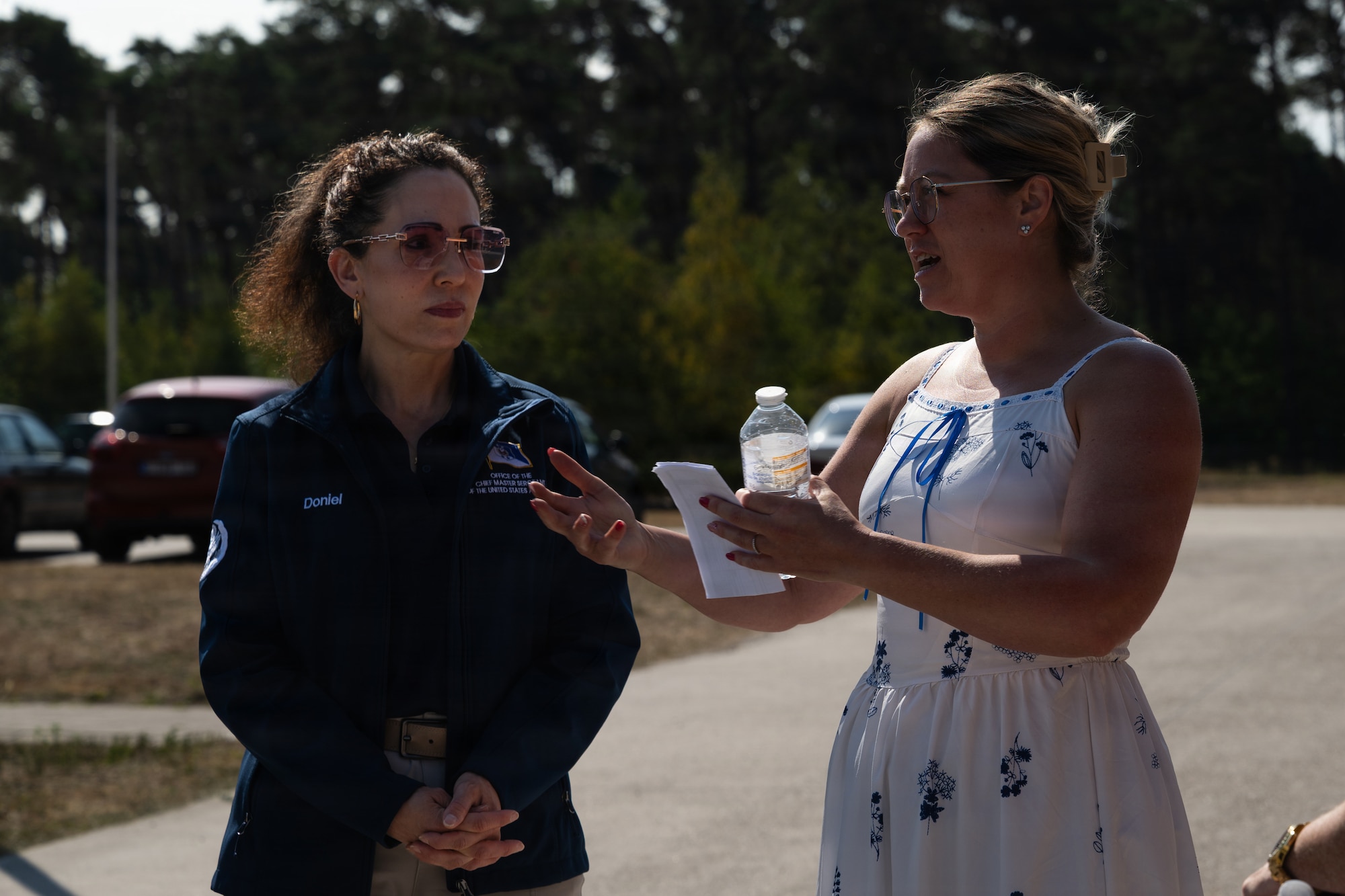 Two women speak with each other.