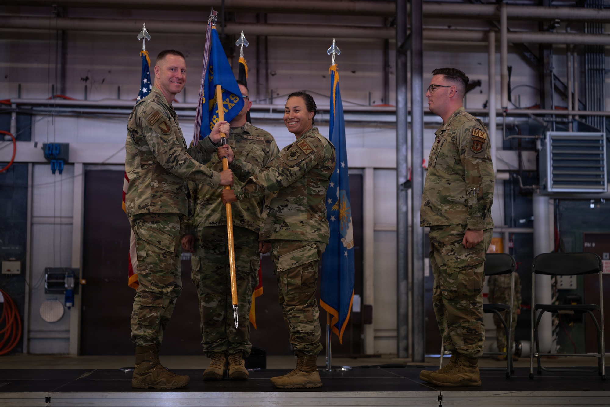 Airman hands Airman a guidon