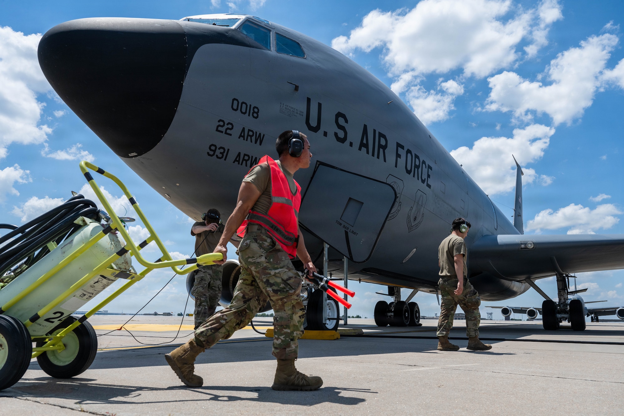 Airman 1st Class Bailey Vu, 722nd Aircraft Maintenance Squadron crew chief, moves a fire bottle across a KC-135 Stratotanker at McConnell Air Force Base, Kansas, July 14, 2026. Fire bottles are moved from engine-to-engine as they start-up for immediate fire response. (U.S. Air Force photo by Airman 1st Class Patrick O’Neill)