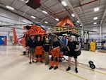 A Coast Guard helicopter aircrew poses with a teen that was successfully rescued from a cliff at Sue-Meg State Park, July 20, 2026. The Air Station Humboldt Bay MH-65 Dolphin helicopter crew hoisted the 13-year-old boy from a ledge approximately 200 feet above Agate Beach and safely transported him to the air station with no reported injuries. (U.S. Coast Guard courtesy photo)