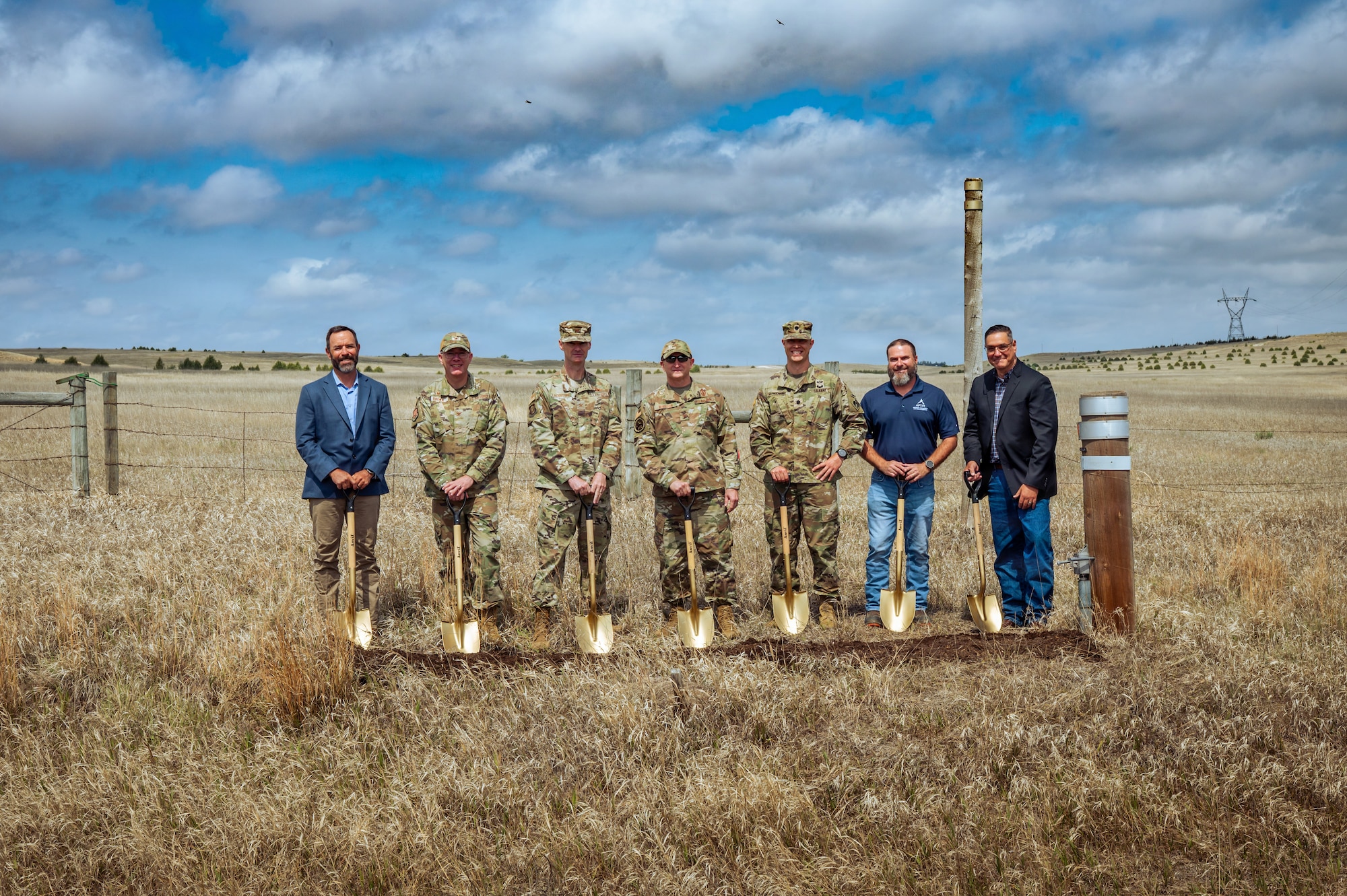 Image of Personnel and leadership posing with shovels in a field.