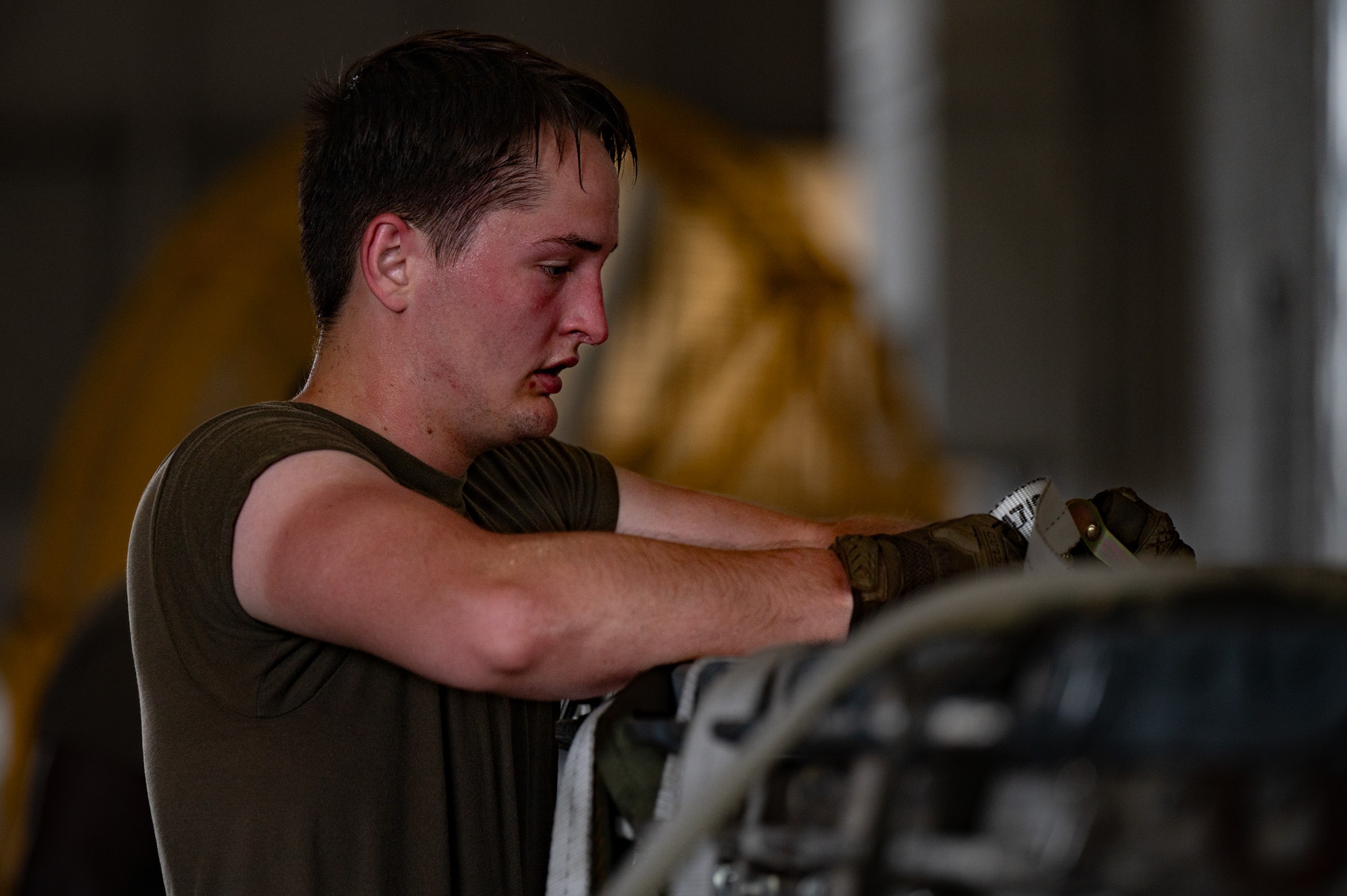 U.S. Air Force Senior Airman Will Addison, 305th Aerial Port Squadron cargo journeyman, works to attach a net set to an empty pallet stack during a Port Dawg Rodeo at Joint Base McGuire-Dix-Lakehurst, N.J., July 10, 2026. The rodeo consisted of six different events; the fitness challenge, Halvorsen 25K cargo loader reconfiguration, 10k standard forklift driving challenge, center of balance, net set relay and a knowledge test. (U.S. Air Force photo by Airman 1st Class Haeleigh Bayle)