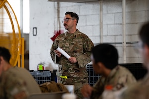 U.S. Air Force Tech. Sgt. Ronell Rosa, 305th Aerial Port Squadron cargo processing noncommissioned officer in charge, briefs participants before the start of the 305th APS Port Dawg Rodeo at Joint Base McGuire-Dix-Lakehurst, N.J., July 10, 2026. Rosa coordinated, organized and oversaw this year’s rodeo. (U.S. Air Force photo by Airman 1st Class Haeleigh Bayle)