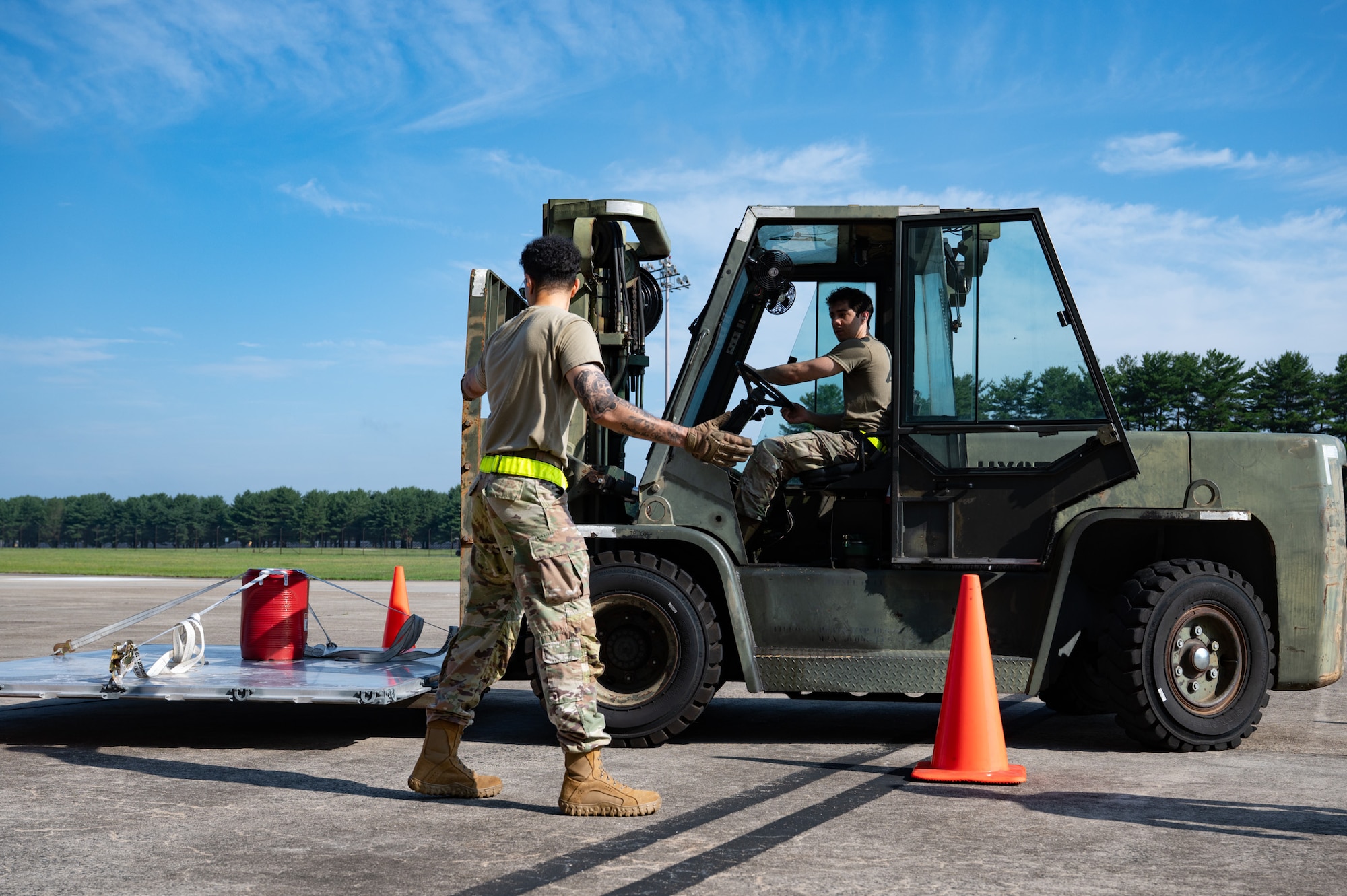 U.S. Air Force Staff Sgt. Rawn Prowell, left, 305th Aerial Port Squadron passenger services supervisor, directs Airman 1st Class Mason Wilson, right, 305th APS cargo specialist, during the 10k standard forklift obstacle course portion of a Port Dawg Rodeo at Joint Base McGuire-Dix-Lakehurst, N.J., July 10, 2026. The rodeo was comprised of four four-person teams that competed in different events to test their career field knowledge. (U.S. Air Force photo by Airman 1st Class Haeleigh Bayle)
