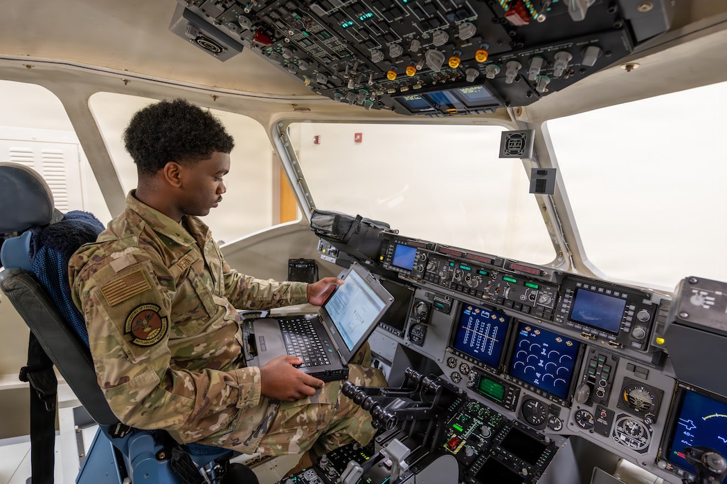 Airman sits in flight deck simulator.