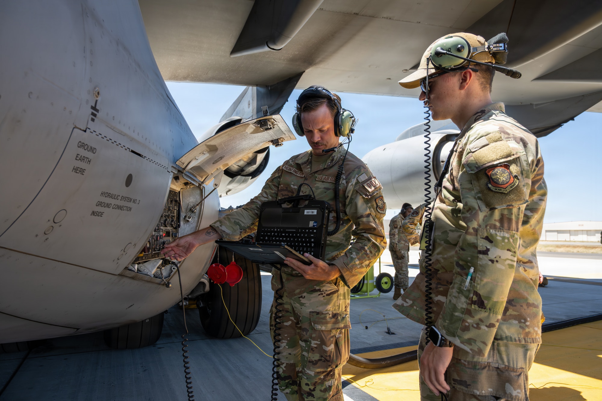 Airmen use control panel on airplane.