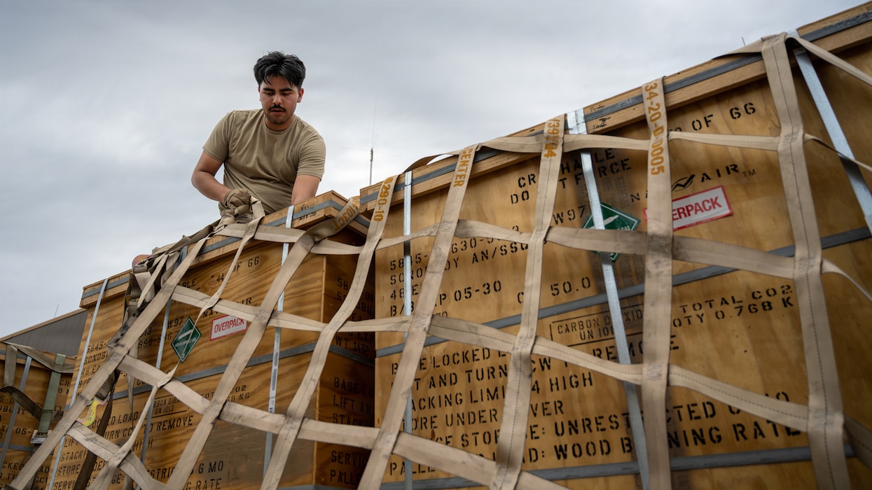 Airman secures cargo to pallet.