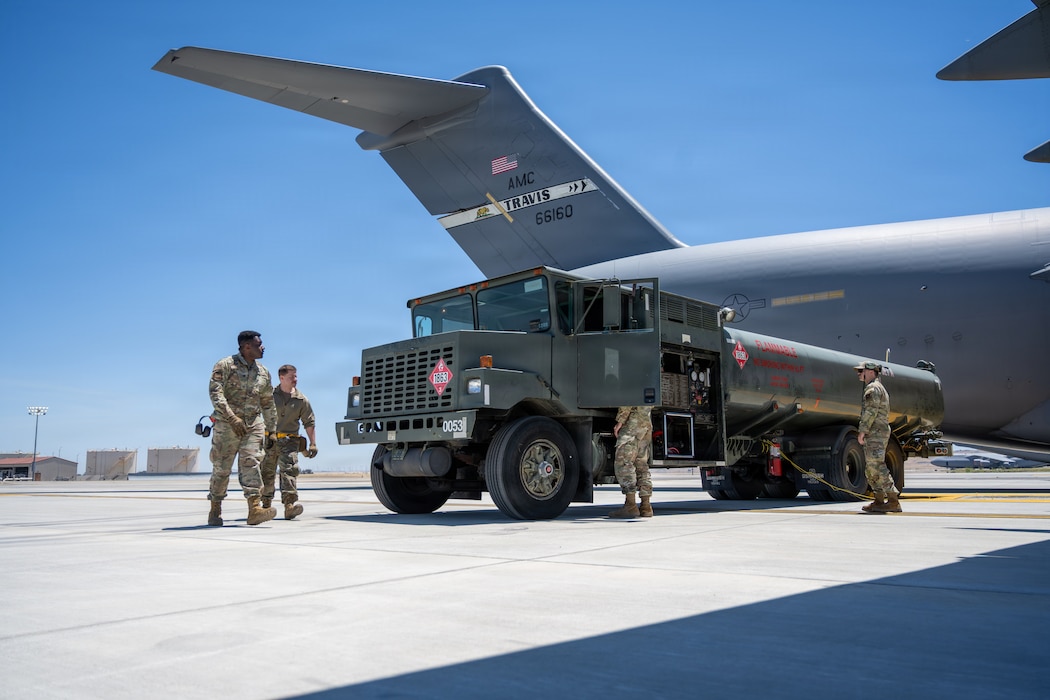 Airmen back fuel truck to airplane.