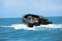 An unmanned Foam Raiding Craft operates through remote control capabilities during Valiant Shield 26 at White Beach, Okinawa, Japan, June 29, 2026. The foam craft was created in part by Marines with Intermediate Repair Company, 3rd Maintenance Battalion, 3rd Marine Logistics Group, as part of Resilient Advanced Manufacturing for Contested Environments, or RAMFORCE, an initiative hosted by the Office of the Under Secretary of Defense for Research and Engineering. The innovative event brought together military personnel, government laboratories, and private industry to evaluate how advanced manufacturing technologies could enable expeditionary forces to repair, replace and even produce critical equipment at the point of need. (U.S. Marine Corps photo by Cpl. Rachel Mason)