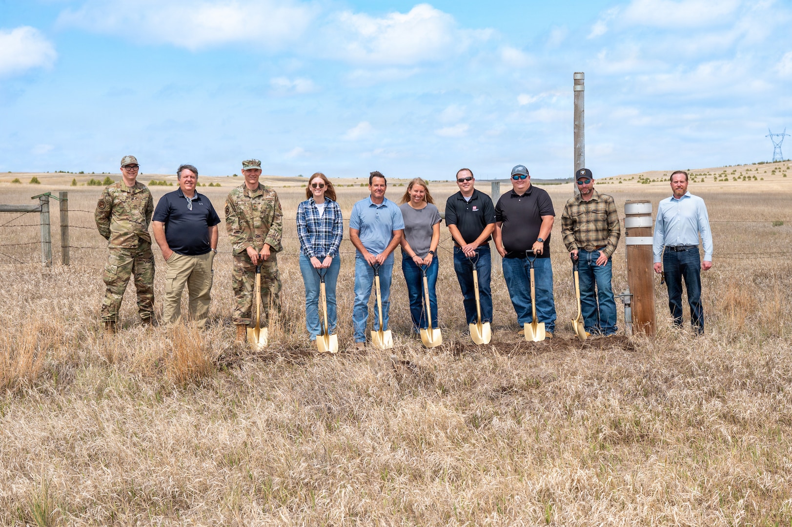 Image of Contractors pose with shovels in a field.