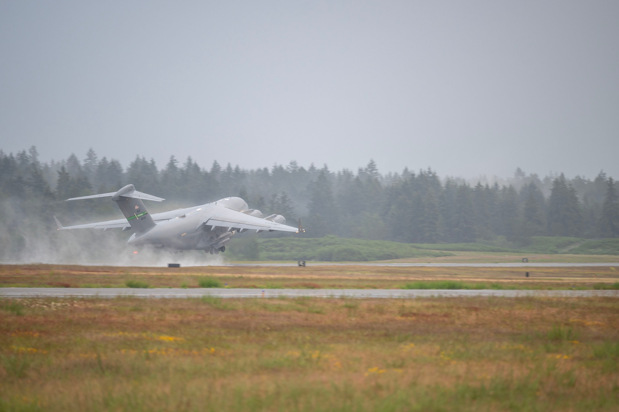 a military plane taking off from a flightline
