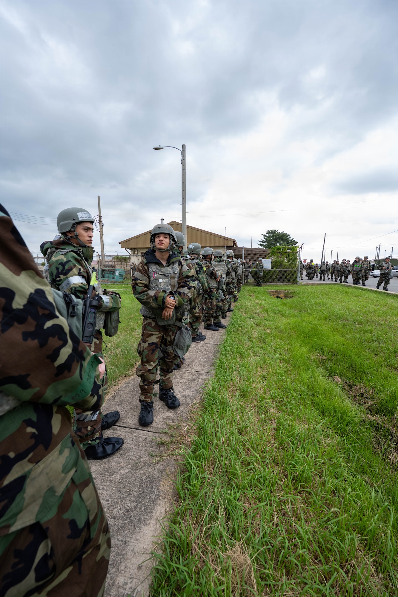 U.S. Air Force Airmen assigned to the 8th Fighter Wing line up for general arming during exercise Beverly Sentinel 26-4 at Kunsan Air Base, Republic of Korea, July 21, 2026. The Wolf Pack was assigned M4 carbines and M18 pistols equipped with blank firing adapters to further strengthen base security operations and weapon familiarization. Training scenarios during the exercise focused on defensive maneuvers and infrastructure protection, reinforcing the wing's capacity to safeguard personnel and assets against potential threats. (U.S. Air Force photo by Senior Airman Tabatha Chapman)