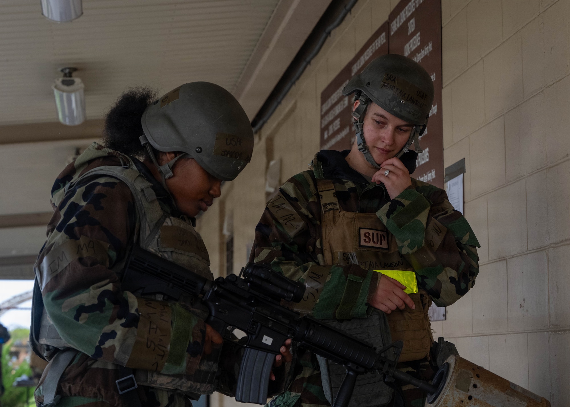 U.S. Air Force Senior Airman Jayda Mayfield, left, 8th Fighter Wing religious affairs journeyman, receives instructions on how to safely clear her M4 carbine from Senior Airman Marina Lawson, right, 8th Logistics Readiness Squadron parts store technician, as part of general arming during exercise Beverly Sentinel 26-4 at Kunsan Air Base, Republic of Korea, July 21, 2026. All weapons issued during the general arming process were cleared and equipped with a blank firing adapter to ensure a safe training environment for the participants. Training events such as Bev. Sent. 26-4 are essential to ensure the Wolf Pack maintains its "Fight Tonight" readiness and can rapidly respond to any crisis. (U.S. Air Force photo by Senior Airman Tabatha Chapman)