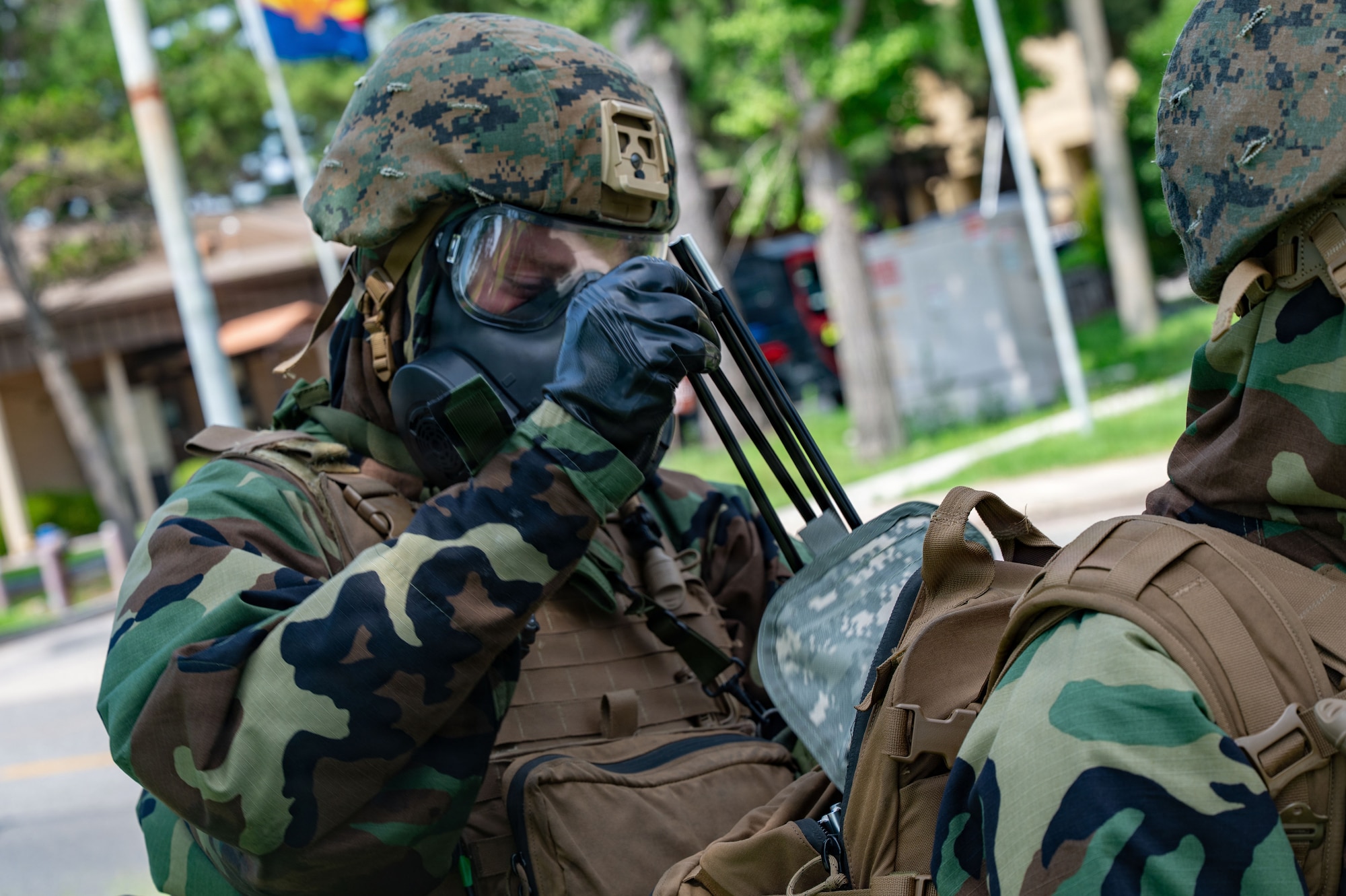 U.S. Marine Lance Cpl. Garrett Bruening, Chemical, Biological, Radiological and Nuclear responders assigned to Marine Wing Support Squadron 171, Marine Air Station, Iwakuni, Japan, retrieves cordon markers for a simulated CBRN contamination during exercise Beverly Sentinel 26-4 at Kunsan Air Base, Republic of Korea, July 22, 2026. By integrating directly during realistic training scenarios, Airmen and Marines learned more about each other’s operational capabilities, building strong professional relationships essential for success in joint combat environments.