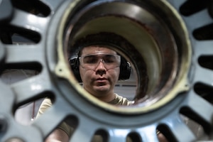 Airman removes bolts from a tire