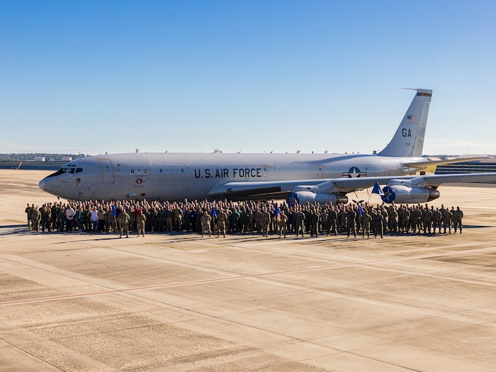 A group photo with an airplane in the background