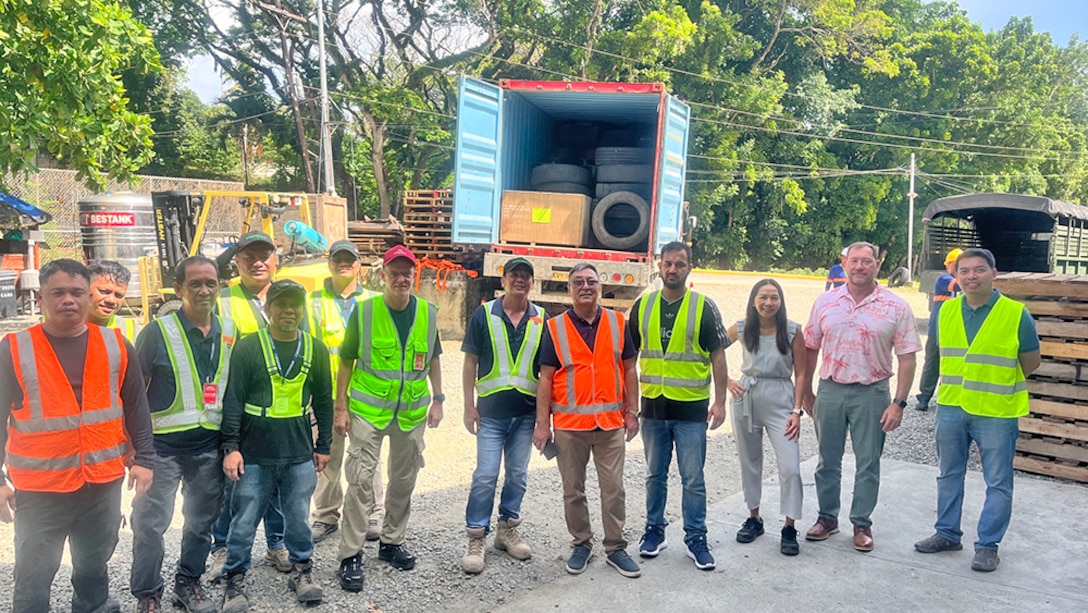 People in safety gear pose at an outdoor work site.