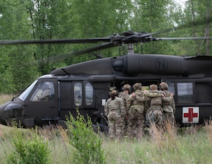 U.S. Air Force Airmen from the 133rd Security Force Squadron load simulate patients onto a UH-60 Black Hawk helicopter from the Charlie Company, 2nd Battalion, 211th Aviation Regiment, 34th Combat Aviation Brigade, Minnesota National Guard, in Arden Hills, Minn., June 11, 2026.