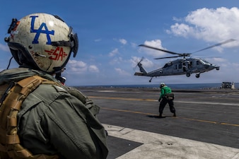 U.S. Navy Capt. Daniel Keeler, commanding officer of Nimitz-class aircraft carrier USS Abraham Lincoln (CVN 72), prepares to fly an MH-60R Sea Hawk helicopter, attached to Helicopter Maritime Strike Squadron (HSM) 71 on Jan. 23, 2026. The Abraham Lincoln Carrier Strike Group is underway conducting routine operations in the U.S. 7th Fleet area of operations. Units assigned to 7th Fleet conduct regular Indo-Pacific patrols to deter aggression, strengthen alliances and partnerships, and advance peace through strength. (U.S. Navy photo by Mass Communication Specialist Seaman Daniel Kimmelman)
