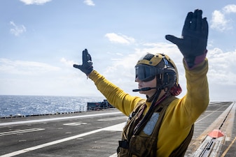 Aviation Boatswain’s Mate 2nd Class Jayda Sitler signals to an E-2D Hawkeye, attached to Airborne Command and Control Squadron 124, on the flight deck of the world’s largest aircraft carrier, USS Gerald R. Ford (CVN 78), while underway in the Mediterranean Sea, April 4, 2026. Gerald R. Ford is on a scheduled deployment in the U.S. 6th Fleet area of operations to support the warfighting effectiveness, lethality and readiness of U.S. Naval Forces Europe-Africa, and defend U.S., Allied and partner interests in the region. (U.S. Navy photo by Mass Communication Specialist Seaman Zamirah Connor)