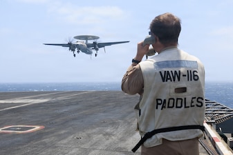 A U.S. Sailor signals an E-2C Hawkeye, attached to Airborne Command and Control Squadron (VAW) 116, for landing on the flight deck aboard of Nimitz-class aircraft carrier USS George H.W. Bush (CVN 77) while sailing in the Arabian Sea, June 9, 2026. USS George H.W. Bush is deployed to the U.S. 5th Fleet area of operations to support maritime security and stability in the Middle East. (U.S. Navy photo)