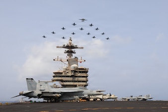 Carrier Air Wing (CVW) 7 flies in formation over USS George H.W. Bush (CVN 77) in the Arabian Sea, June 30, 2026. George H.W. Bush is deployed to the U.S. 5th Fleet area of operations to support maritime security and stability in the Middle East. (U.S. Navy photo)