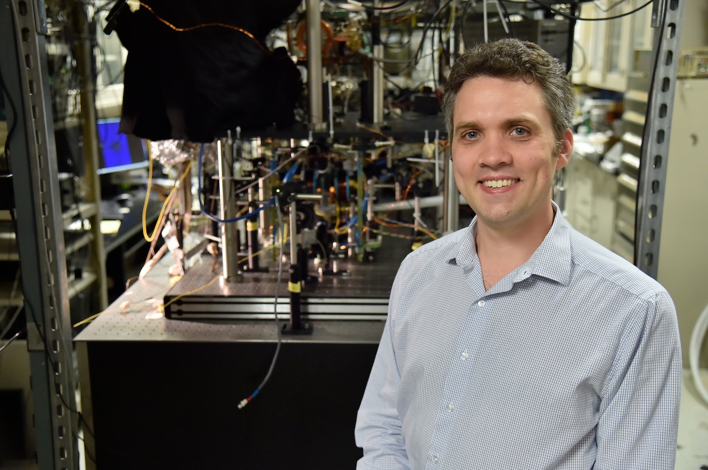 Adam Black, Ph.D., director of the U.S. Naval Research Laboratory’s Quantum Science Institute, stands in front of a quantum research experiment at NRL. The institute coordinates quantum research across the laboratory to advance technologies supporting future Navy capabilities.  (U.S. Navy photo by Jonathan Steffen)