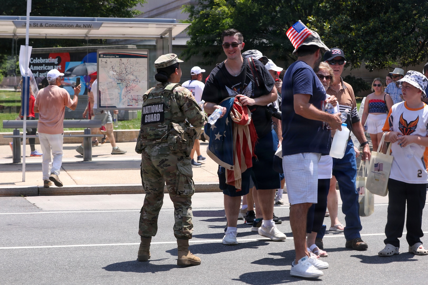U.S. National Guard members supporting DC Safe and Beautiful hand out bottles of water to tourists visiting the Great American State Fair during Independence Day celebrations in Washington, D.C., July 4, 2026. About 5,000 National Guard members are supporting the mission, providing critical assistance to the Metropolitan Police Department to help ensure the safety of residents, commuters, and visitors throughout the District.