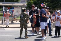 U.S. National Guard members supporting DC Safe and Beautiful hand out bottles of water to tourists visiting the Great American State Fair during Independence Day celebrations in Washington, D.C., July 4, 2026. About 5,000 National Guard members are supporting the mission, providing critical assistance to the Metropolitan Police Department to help ensure the safety of residents, commuters, and visitors throughout the District.