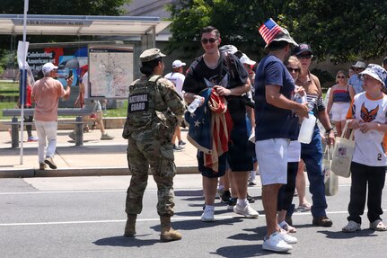 U.S. National Guard members supporting DC Safe and Beautiful hand out bottles of water to tourists visiting the Great American State Fair during Independence Day celebrations in Washington, D.C., July 4, 2026. About 5,000 National Guard members are supporting the mission, providing critical assistance to the Metropolitan Police Department to help ensure the safety of residents, commuters, and visitors throughout the District.