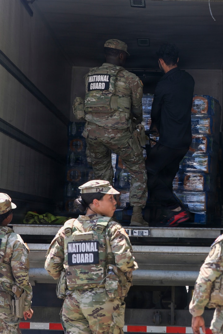 U.S. National Guard members supporting DC Safe and Beautiful hand out bottles of water to tourists visiting the Great American State Fair during Independence Day celebrations in Washington, D.C., July 4, 2026. About 5,000 National Guard members are supporting the mission, providing critical assistance to the Metropolitan Police Department to help ensure the safety of residents, commuters, and visitors throughout the District.
