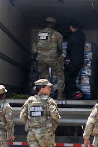 U.S. National Guard members supporting DC Safe and Beautiful hand out bottles of water to tourists visiting the Great American State Fair during Independence Day celebrations in Washington, D.C., July 4, 2026. About 5,000 National Guard members are supporting the mission, providing critical assistance to the Metropolitan Police Department to help ensure the safety of residents, commuters, and visitors throughout the District.