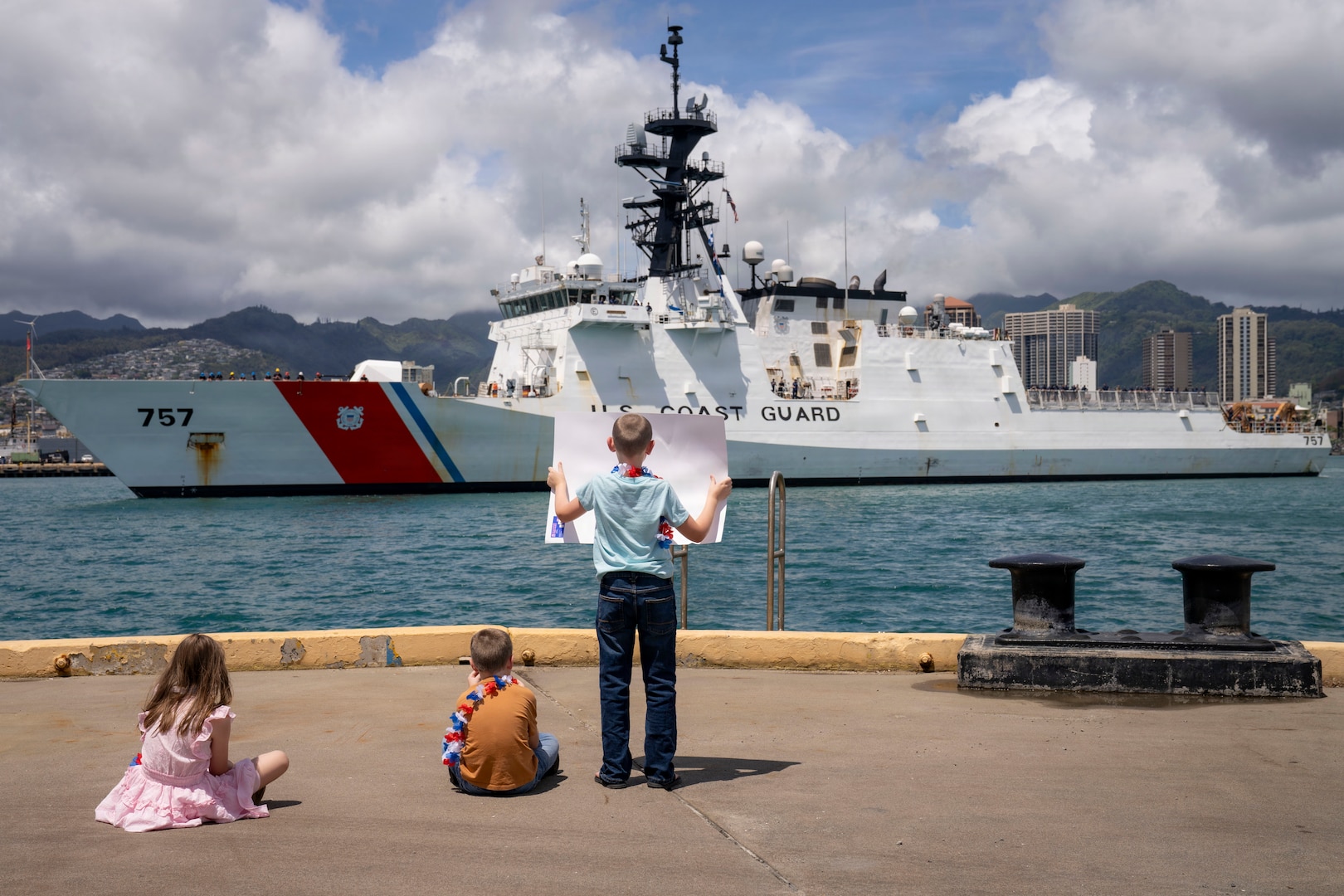 USCGC Midgett (WMSL 757) family members greet the cutter as it returns to home port at Coast Guard Base Honolulu, July 20, 2026. The cutter returned from a five-month deployment to the Western Pacific. (U.S. Coast Guard photo by Petty Officer 2nd Class Mikaela McGee)