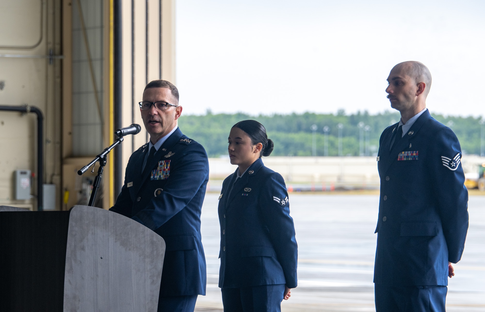 U.S. Air Force Lt. Gen. Robert Davis, commander of the Alaskan NORAD Region, Alaskan Command and Eleventh Air Force, speaks while Airman 1st Class Allyson Bravo, 673d Civil Engineer Squadron, left, and Staff Sgt. Bradley Lang, 673d Medical Group physical medicine technician, right, listen during a change-of-command ceremony on Joint Base Elmendorf-Richardson, Alaska. July 22, 2026.