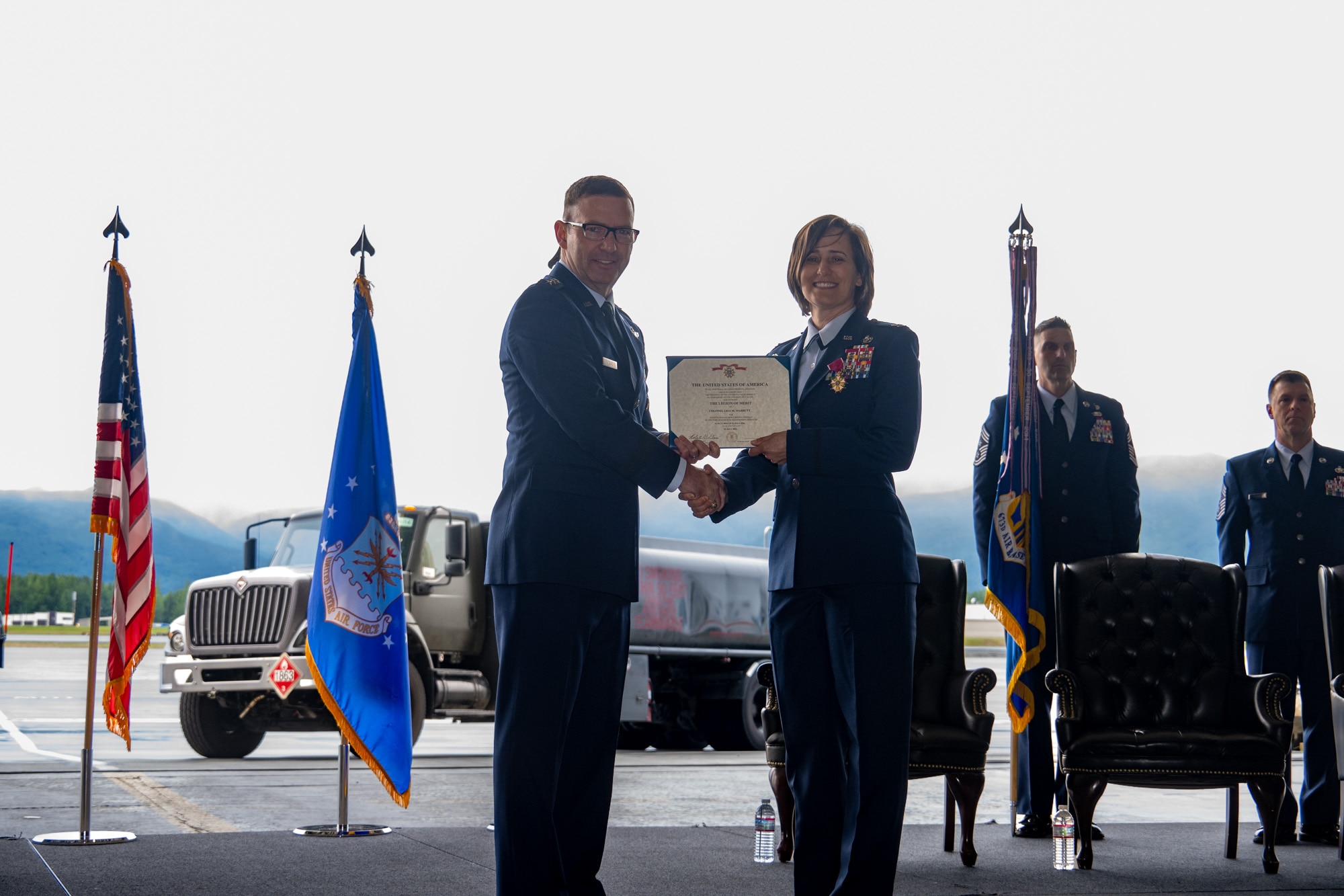 U.S. Air Force Lt. Gen. Robert Davis, commander of the Alaskan NORAD Region, Alaskan Command and Eleventh Air Force, presents U.S. Air Force Col. Lisa Mabbutt, outgoing 673d Air Base Wing commander, with a Legion of Merit during a change-of-command ceremony on Joint Base Elmendorf-Richardson, Alaska, July 22, 2026.