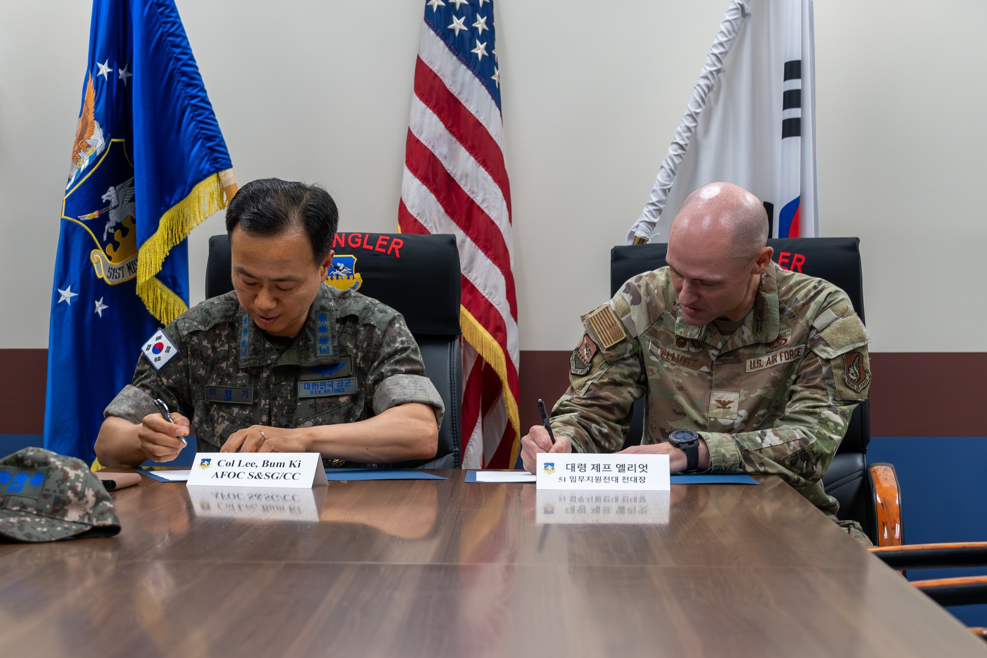 A USAF and ROKAF commander sign a memorandum.