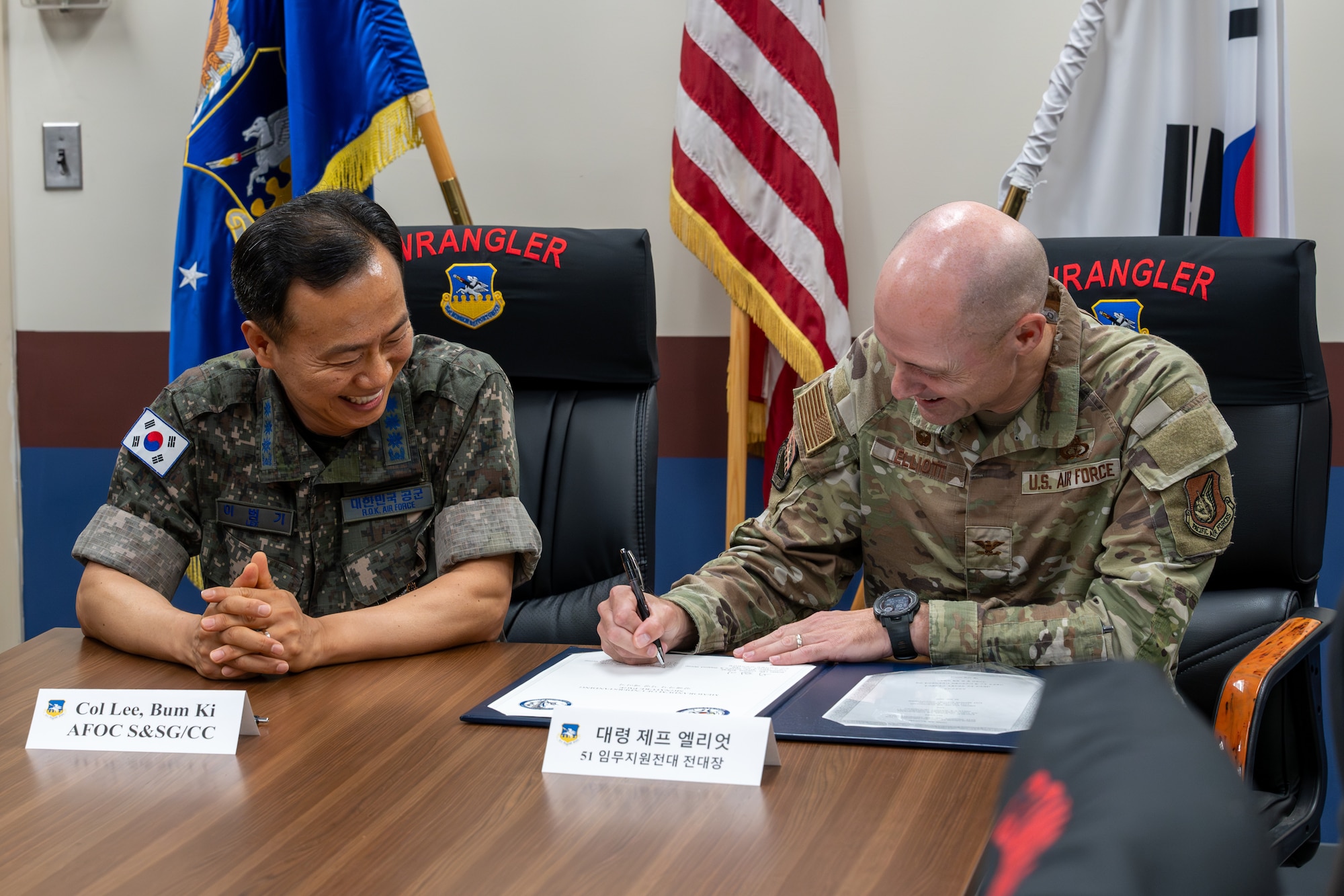 A USAF and ROKAF commander sign a memorandum.