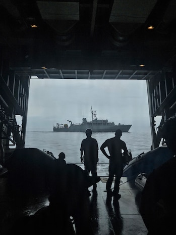 U.S. Navy Explosive Ordnance Disposal Mobile Unit 5 and Japan Maritime Self-Defense Force sailors watch from the rear hatch of JMSDF mine sweeper tender JS Bungo (MST-464) as ocean mine sweeper JS Awaji (MSO-304) passes during Mine Warfare Exercise 2JA, July 14, 2026. 2JA is part of a year-long series of bilateral exercises between the U.S. Navy and JMSDF to strengthen interoperability and increase proficiency in mine countermeasure operations. (U.S. Navy photo by Lt. Jacob Kinnear)