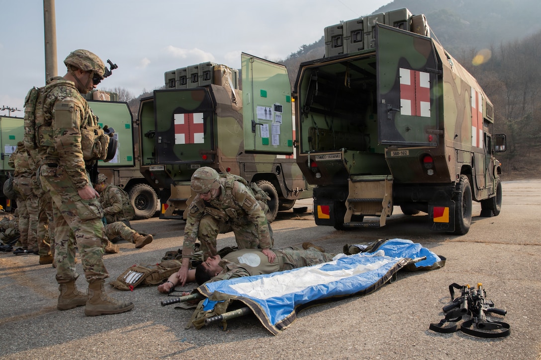 U.S. Army Staff Sgt. Benjamin Halliburton begins medical care for Spc. Dylan Breceda during a combat casualty care exercise conducted by the 560th Medical Company (Ground Ambulance) at Camp Stanley, South Korea, on March 9, 2026. The Dragon Lift exercise evaluates combined medical capacity and interoperability to ensure effective casualty care across the Korean theater. (U.S. Army photo by Spc. Jakaiyah Rumedon.)