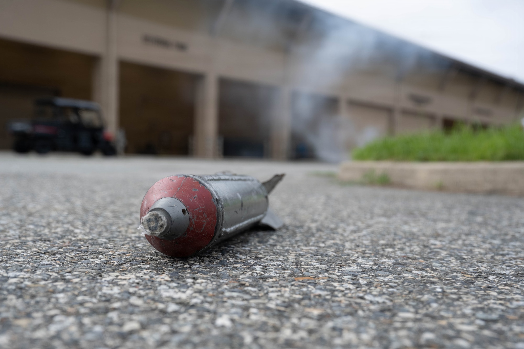 A simulated sub-munition lies on the ground.