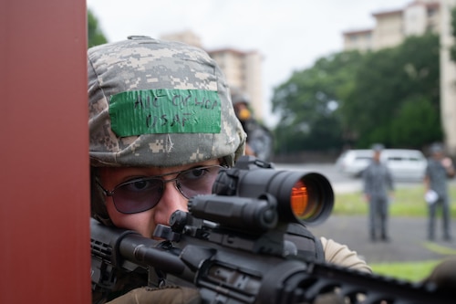 An Airman looks down the crosshair on a rifle.