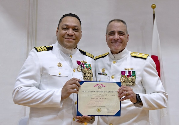 YOKOSUKA, Japan (July 23, 2026) — Rear Adm. Kevin J. Brown, commander, Naval Medical Forces Pacific; director, Defense Health Network Pacific Rim; and chief of the Navy Medical Corps, presents the Legion of Merit to Capt. Torrin W. Velazquez during the U.S. Navy Medicine Readiness and Training Command Yokosuka change of command ceremony at Commander, Fleet Activities Yokosuka's C2 Auditorium. The award recognized Velazquez's exceptionally meritorious service as commanding officer of USNMRTC Yokosuka and director of U.S. Naval Hospital (USNH) Yokosuka. USNMRTC Yokosuka delivers patient- and family-centered healthcare while developing and delivering trained, ready medical forces in support of U.S. Indo-Pacific Command. (U.S. Navy photo by Daniel Taylor/USNH Yokosuka Public Affairs)