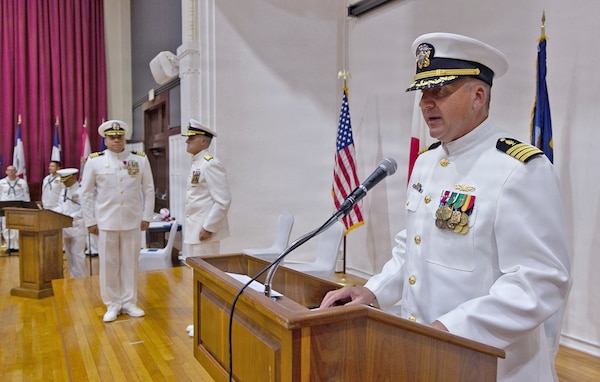 YOKOSUKA, Japan (July 23, 2026) — Capt. Joshua A. Miller reads his official orders during the U.S. Navy Medicine Readiness and Training Command Yokosuka change of command ceremony at Commander, Fleet Activities Yokosuka's C2 Auditorium. The reading of orders formally transferred command from Capt. Torrin W. Velazquez to Miller. USNMRTC Yokosuka delivers patient- and family-centered healthcare while developing and delivering trained, ready medical forces in support of U.S. Indo-Pacific Command. (U.S. Navy photo by Daniel Taylor/USNH Yokosuka Public Affairs)