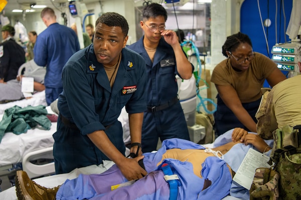 U.S. Navy Hospital Corpsman 1st Class Renaldo Watts, assigned to Wasp-class amphibious assault ship USS Essex (LHD 2), applies a tourniquet to the leg of a simulated injured patient during a mass casualty drill during Exercise Rim of the Pacific (RIMPAC) 2026, July 10, 2026. Thirty nations, 30 ships, 5 submarines, 15 national land forces, more than 190 aircraft and more than 30,000 personnel are participating in RIMPAC in and around the Hawaiian Islands, June 24 to July 31. The world's largest international maritime exercise, RIMPAC provides a unique training opportunity while fostering and sustaining cooperative relationships among participants critical to ensuring the safety of sea lanes and security on the world's oceans. RIMPAC 2026 is the 30th exercise in the series that began in 1971. (U.S. Navy photo by Mass Communication Specialist Seaman Apprentice Samuel B. Park)
