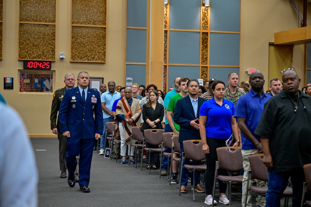 A one-star Air Force General and a three-star Army General waling down the aisle towards the stage during a ceremony