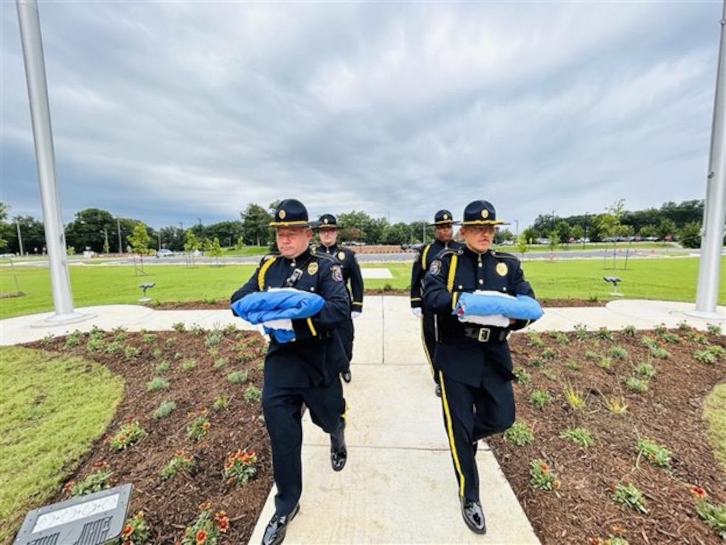 An Honor Guard carrying flags after removing them from an outside flag pole