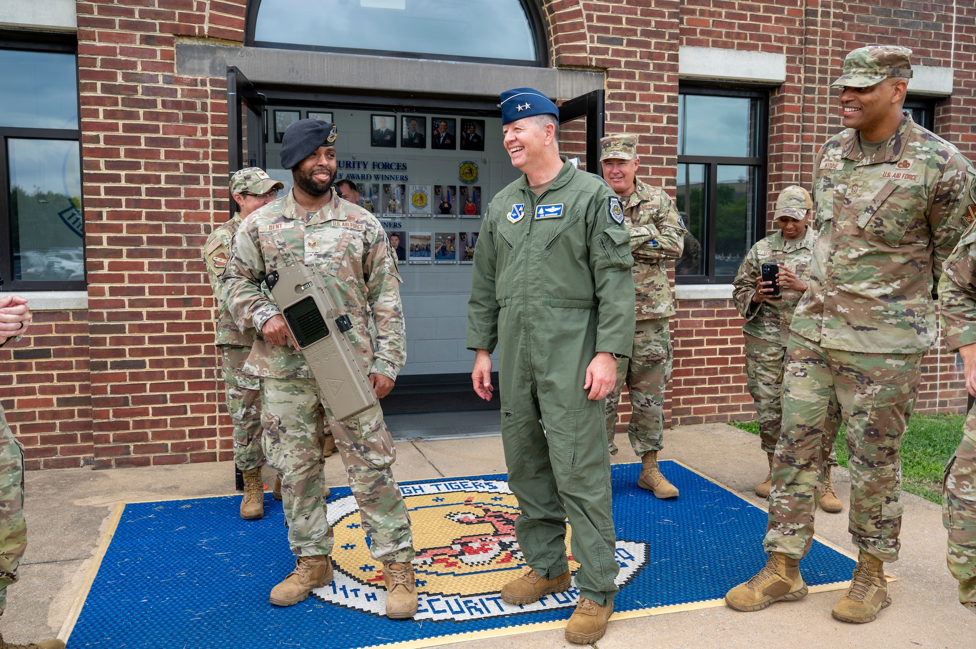 U.S.Air Force Maj. Gen. stands out side of building next to a Security Forces Airman holding a Dronebuster