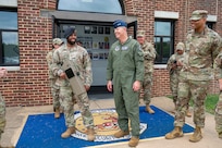 U.S.Air Force Maj. Gen. stands out side of building next to a Security Forces Airman holding a Dronebuster
