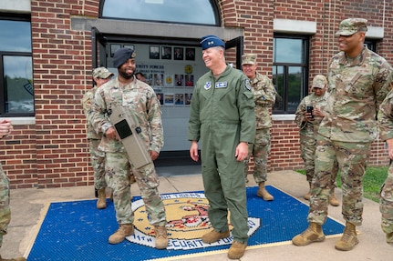 U.S.Air Force Maj. Gen. stands out side of building next to a Security Forces Airman holding a Dronebuster