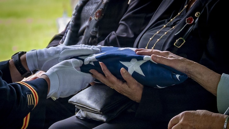 U.S. Army Capt. Christopher Barnabei, the Connecticut National Guard's casualty operations officer in charge, hands a folded American Flag to the family of U.S. Army Air Forces Tech. Sgt. Donald A. Dorman at his funeral services at Oak Hill Cemetery, Southington, Conn. June 23, 2026.
